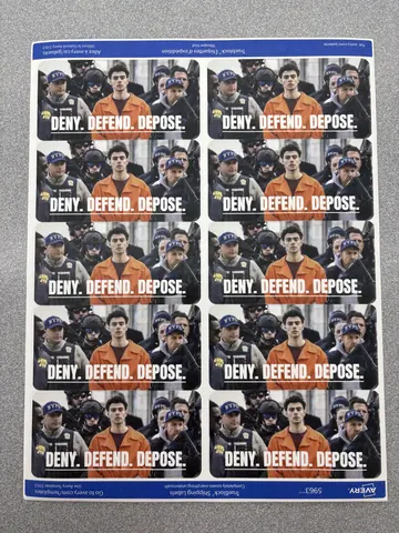 A printed sheet containing repeated rectangular stickers or labels showing Luigi Mangione in custody with the words 'DENY. DEFEND. DEPOSE.'