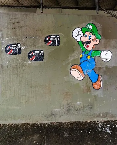 Street-art image of Luigi painted on a concrete wall beside several small black-and-red DDD stickers.